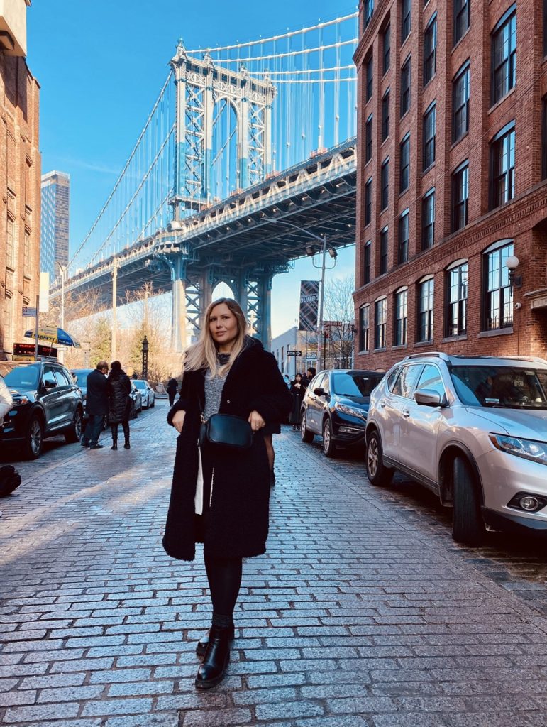 Ragazza a Dumbo, Brooklyn, con il Manhattan Bridge come sfondo. New York
